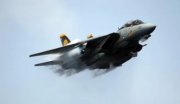 A US Navy (USN) F-14D Tomcat standard fleet fighter aircraft (Aircraft number 100), Fighter Squadron 31 (VF-31, ÒTomcattersÓ), makes a near-supersonic low-level fly-by above the USN Nimitz Class Aircraft Carrier, USS THEODORE ROOSEVELT (CVN 71), while the USS ROOSEVELT is participating in a Joint Task Force Exercise (JTFEX) with the USN Nimitz Class Aircraft Carrier, USS DWIGHT D. EISENHOWER (CVN 69) in the Atlantic Ocean (AOC).